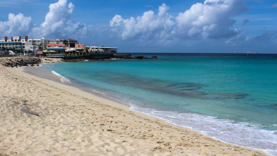 Famous Maho Beach known for plane landing over head with bars on the back of the picture on St Maarten / St Martin