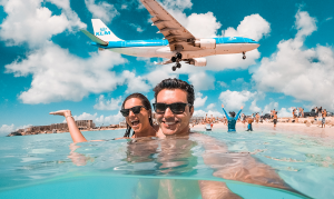 Tourists experiencing the world-famous sight of plane landing over Maho beach on St Maarten / St Martin