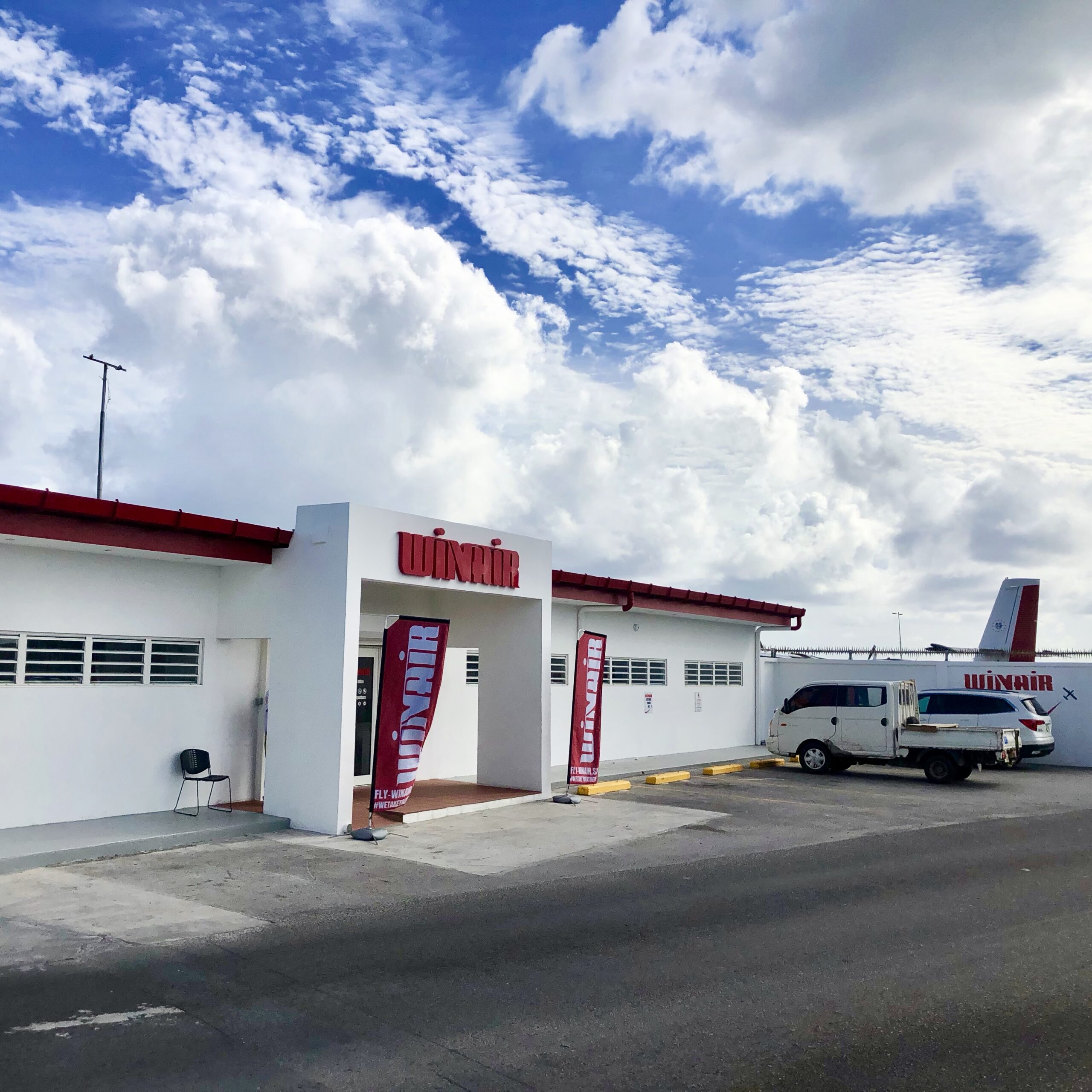 The Winair office next to the Princess Juliana International Airport SXM with the blue sky and white clouds in the background