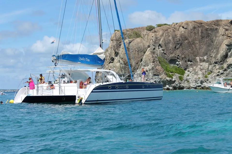 A catemaran in the sea with the name Quality time