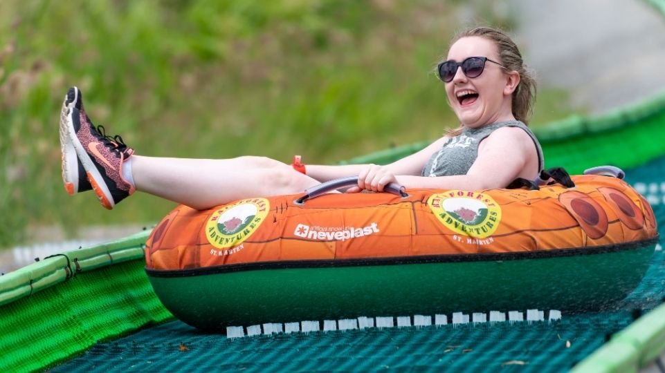 A girl sitting on a band sliding and laughing at rainforest adventures St Maarten