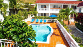 Pool and orange tiled terrace at central square of L’ Esperance Hotel