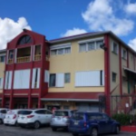 Cars parked outside the front side of Carl’s Unique Inn in Cole Bay