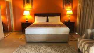 Double bed room with red wall in Carl’s Unique Inn