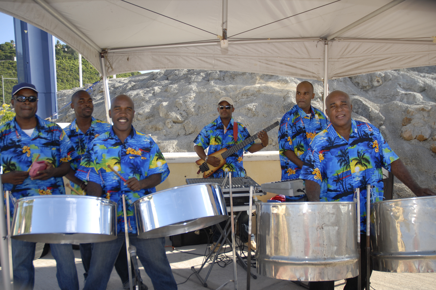 Dow’s Musical Foundation dressed in blue with steelpans in action under a tent