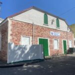 brick building in philipsburg back street with green doors