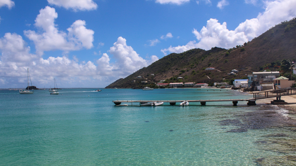 Mooring of Grand Case on the French side of St Martin, with beach and restaurants on the right and Creole Rock on the left