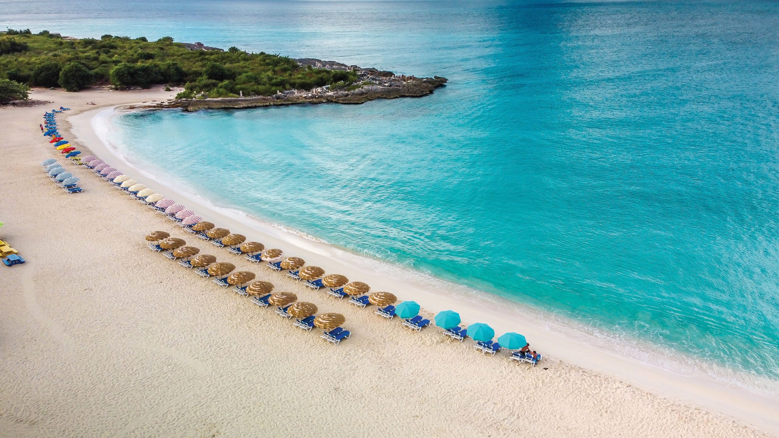 A view from above to Mullet Bay beach, with bluest water, beach chairs and umbrellas