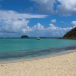 Petite Plage of St Martin with blue water and St Martin's hills far back on the picture