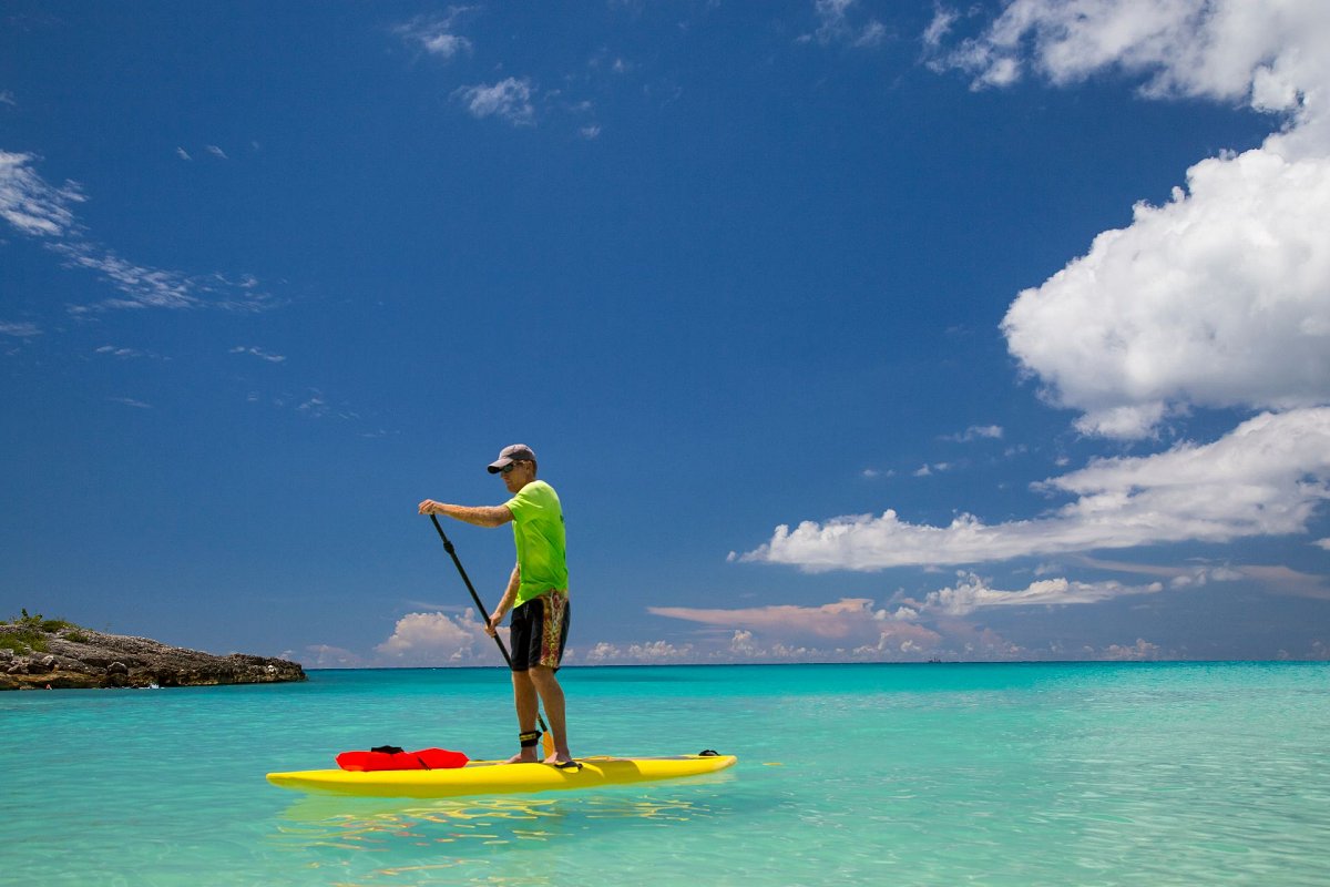 Tourist paddle boarding during St Maarten vacation