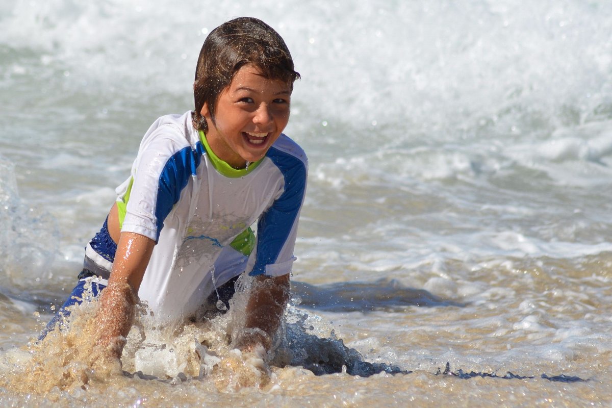 Boy doing paddle boarding in the surf of Orient Bay st Martin