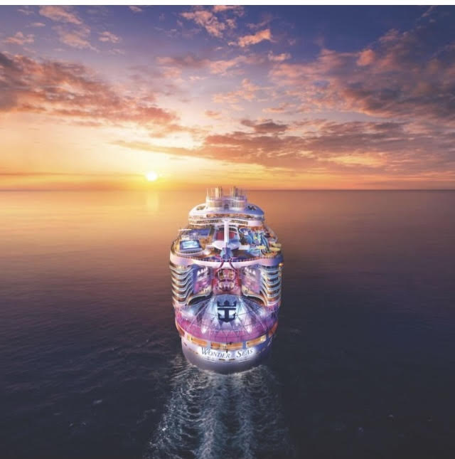 Cruise Ship setting sails on water with a purple and pink sky during sunset