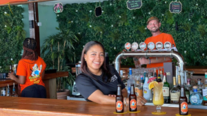 Woman serving beers at the Dutch Blonde Beach Bar on the Boardwalk in Philipsburg