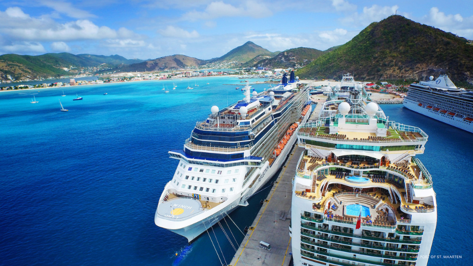 Two cruise ships docked at St Maarten cruise port in Philipsburg with a view of hills in the background