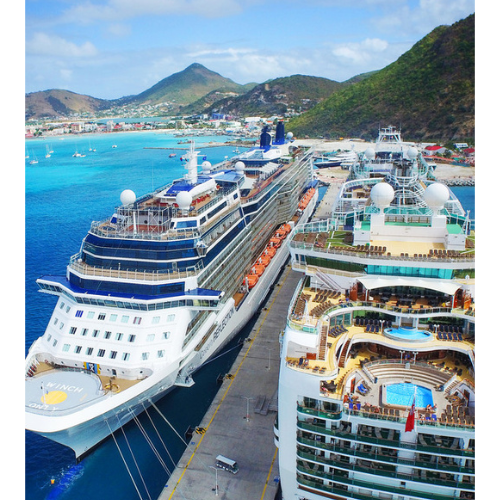 Two cruise ships docked at St Maarten cruise port in Philipsburg with a view of hills in the background