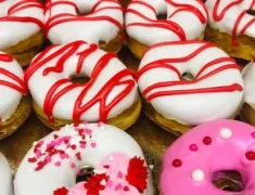 White donuts with red drizzel by Carls and Sons Bakery