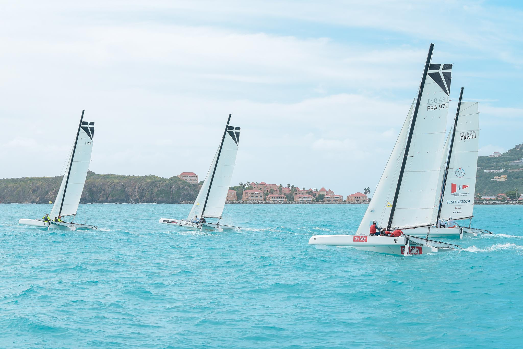 Three sailing boats sailing on the St Maarten turquoise waters