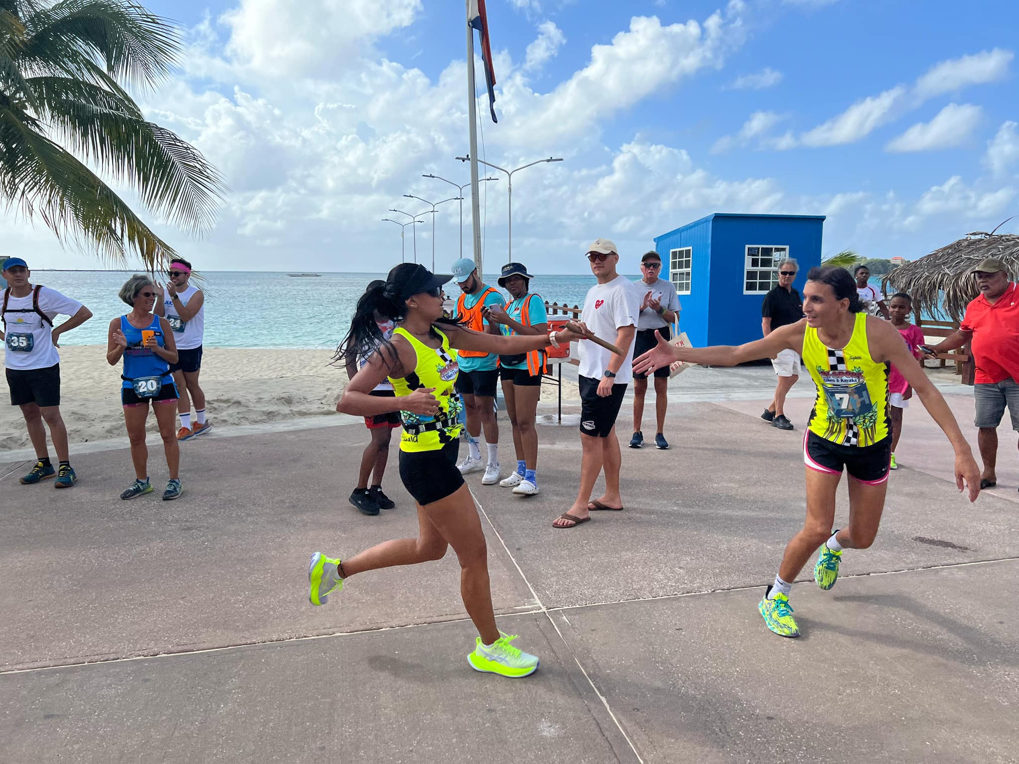 Tri-Sport SXM Triathlon Boardwalk Philipsburg two ladies passing the Triathlon Stick to each other