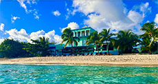 Azure Art Hotel and Simpson Bay Beach with palm trees and waves in front 