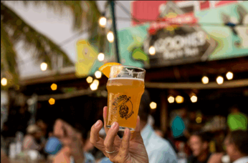 A man holding a beer in de middle with at Pelikaan Brewery