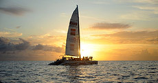 Catamaran Lambada sailing with group with St Maarten sunset in background 