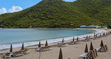 Folded parasols at Anse Marcel Beach St Martin with sea and green hills 