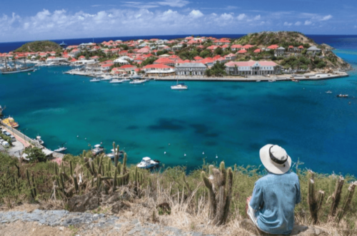 A person sitting on a hill top looking at St Barths