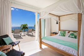 Bed with curtains at Villa Aqua St. Maarten