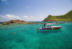 Creole Rock on the French Side in behind the boat in the water 