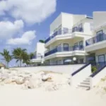 White seaside condos and palm trees of Flamingo Beach Resort