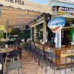 the bar' the pier' in st maarten with stools and creations hanging on the bamboo wall