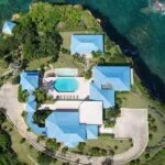 Villa with blue roof surrounded with nature and a swimming pool