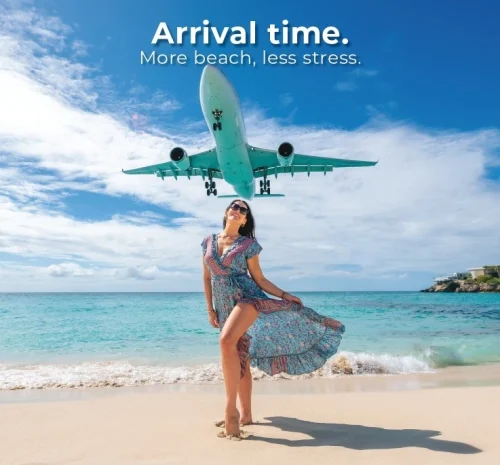 Plane flying over woman standing on Maho Beach