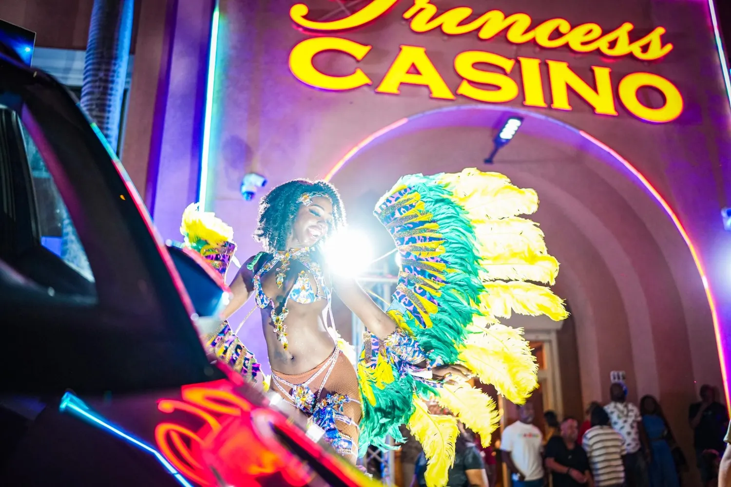 Woman in colorful outfit dancing in front of Sunset Princess Casino