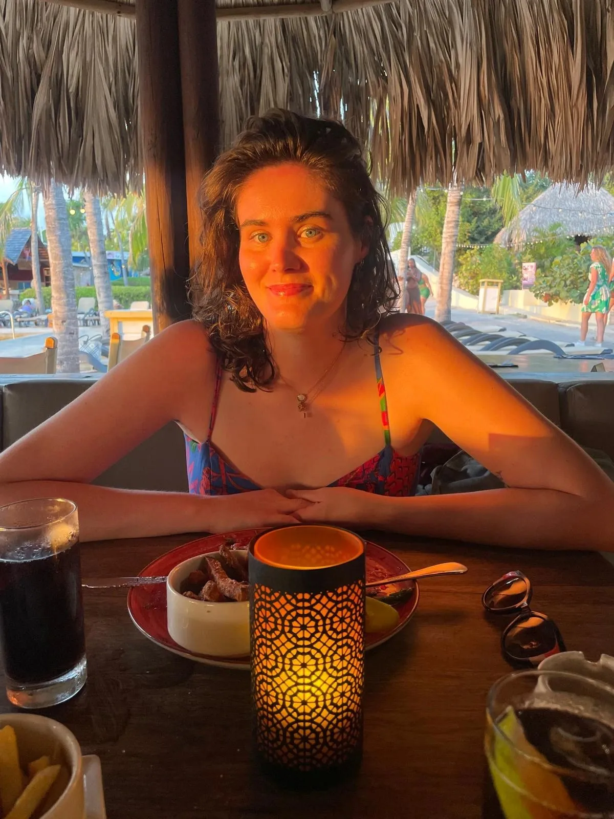 Woman sitting at a restaurant with sunset rays shining on her face