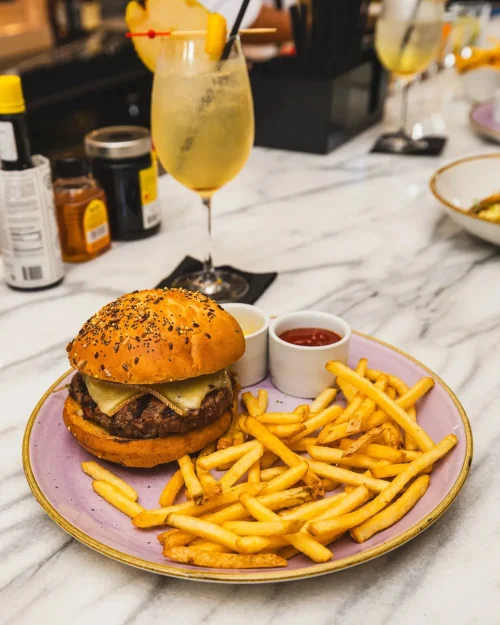 Cheeseburger and fries on a plate at Pardon My French restaurant