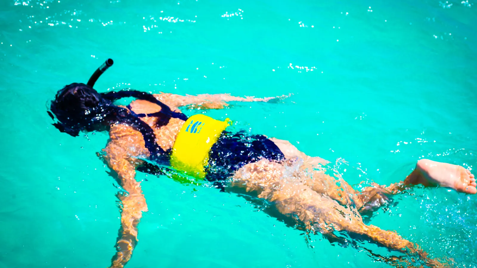 Snorkeler swims through turquoise water off St. Maarten.