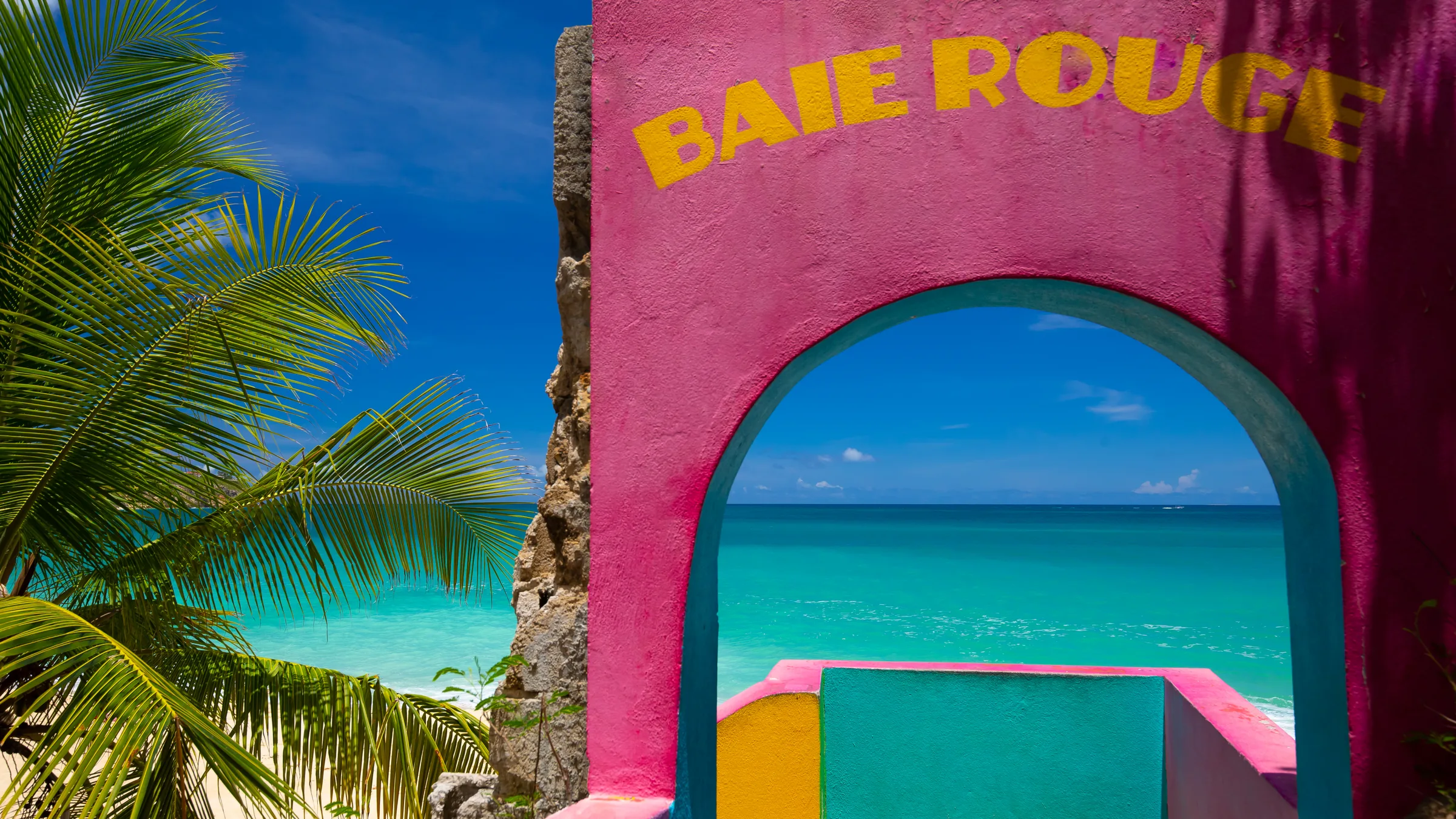 Colorful Baie Rouge viewpoint frames turquoise Caribbean water.